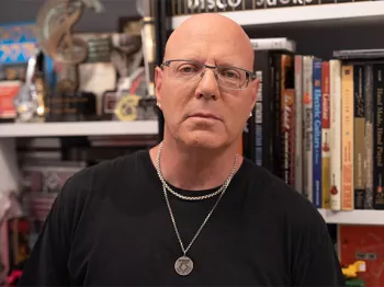 Jay Jay French in front of bookshelf in his home