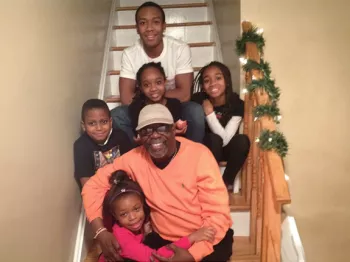 Black man and his family sitting on stairs