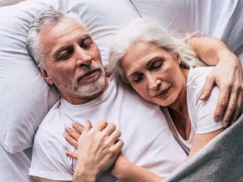 A senior couple cuddling in bed together