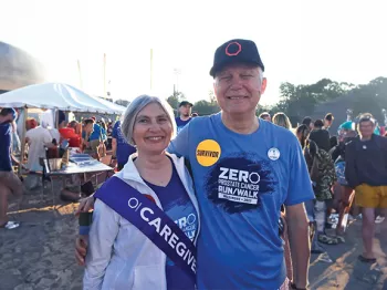 A prostate cancer survivor and his wife who is wearing a Caregiver sash at a Run/Walk event