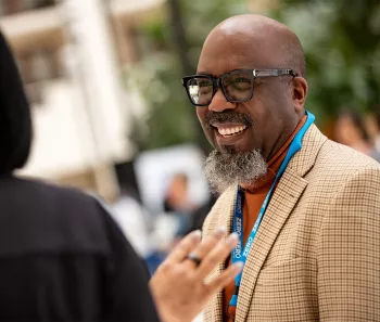 Reggie Tucker-Seely smiling while he talks to another person
