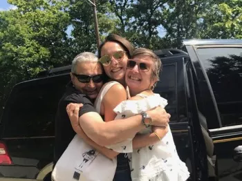 Athena Bogdanos and family hugging happily in front of a SUV