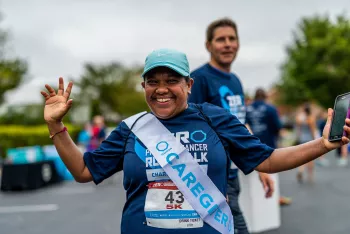 All smiles wearing a caregiver sash attending a 5k run/walk event for ZERO prostate cancer