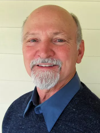 Bolding middle-aged man with grey beard