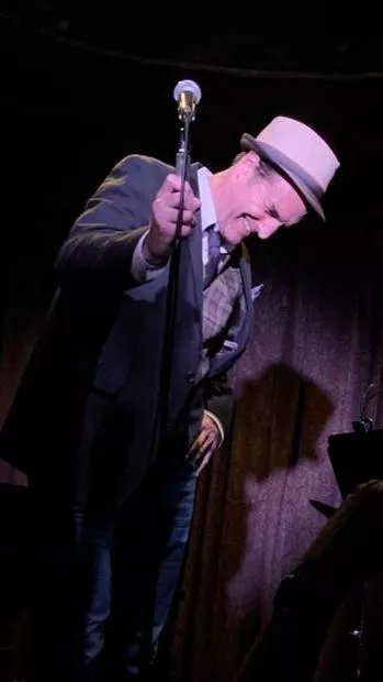 Patrick Boll laughing on stage while performing Cabaret