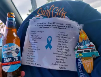 Randy answering what comes next with a shirt of Prostate Cancer victims and a Sam '76 beer