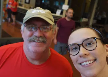 Caucasian man with a baseball hat and glasses taking a selfie with a girl with glasses