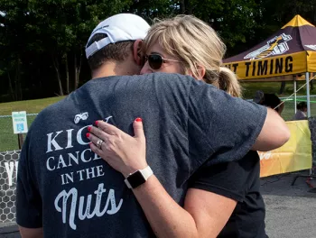The Fergs in a hug where Mike's shirt reads "Kick cancer in the nuts"