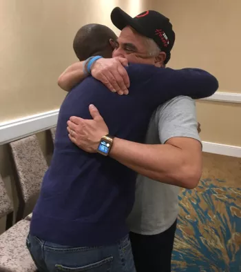 Zero  Board Member Robert Ginyard hugging Robert Herrera