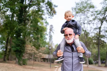 Jeffrey Wilde carrying grandson on his shoulders