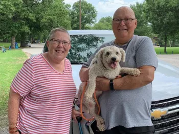 Dale Golgart, his wife Glenda, and their dog Tucker standing for a picture