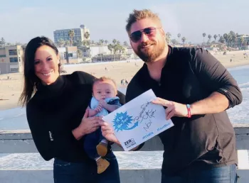 Jimmy Charles' family holding up sign saying Bakersfield at a pier