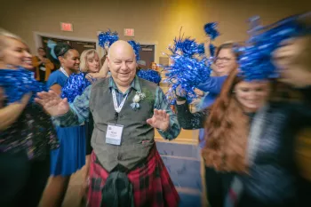 Mark at the Bold for Blue event surrounded by people waving blue pom poms