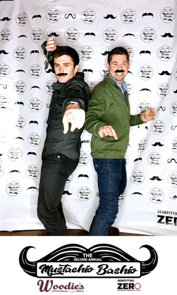 Two men wearing fake mustaches posing in front of the camera