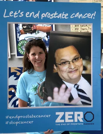 Woman holding up Selfie cutout of Lets End Prostate Cancer
