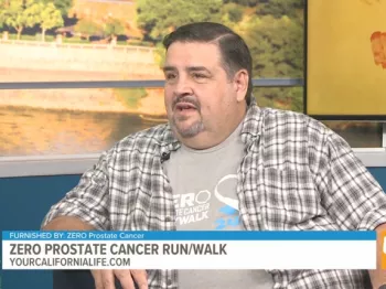 Joe Thompson wearing flannel sitting on couch