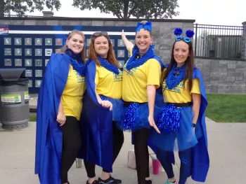 Women posing in blue capes