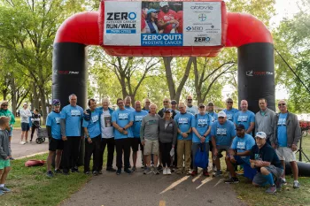 group of people posing in front of starting line banner