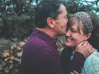 Man kissing wife on forehead