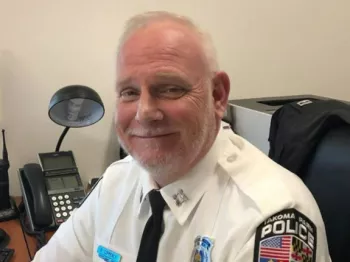 Police Officer in Uniform smiling and sitting down