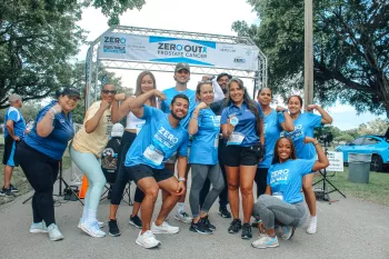 A large group of people wearing Run/Walk shirts in front of a start line