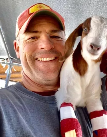 Cowboy Max in a baseball hat and matching goat in socks