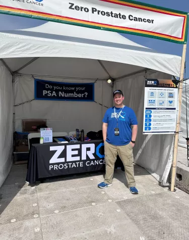 Young man standing next to a ZERO booth