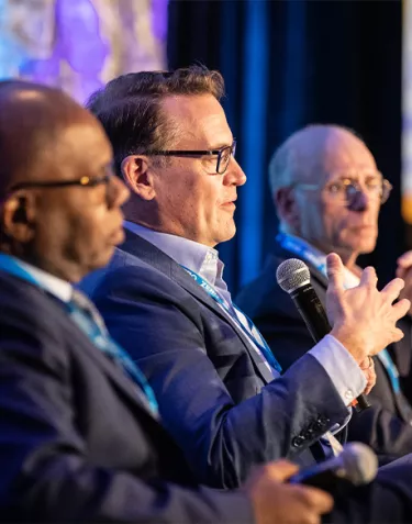 Three men during a panel discussion at Summit 2023