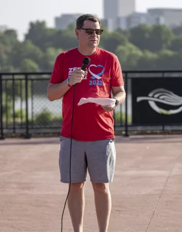 Man in a red t-shirt speaking to a microphone