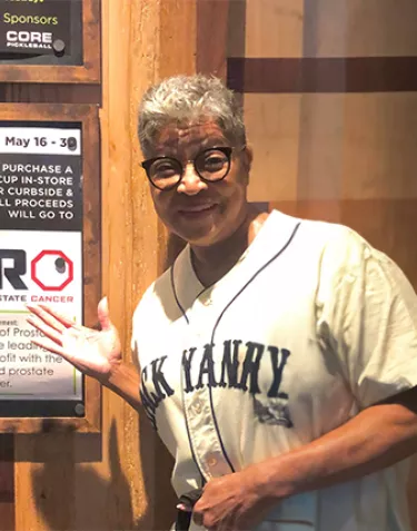 Vivian Avery next to a sign at a ZERO fundraising event