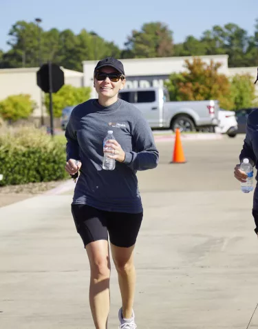 Two women in grey t-shirts running