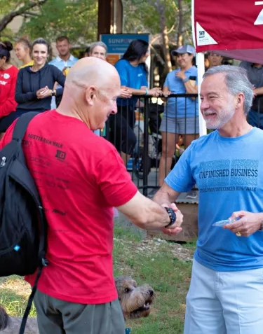 Two man wearing t-shirts and shaking hands