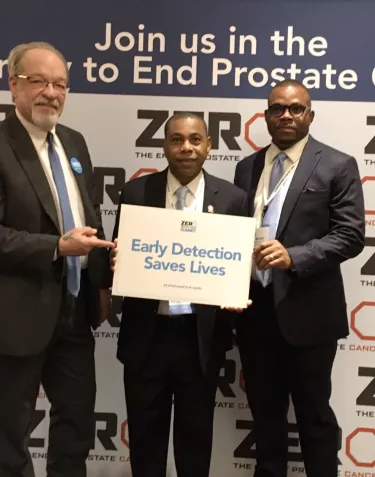 Mike and others hold a sign that says 'Early Detection Saves Lives'