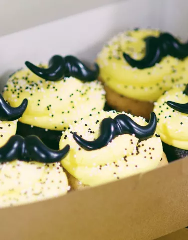 Cupcakes with icing shaped like mustaches for Hops & Handlebars 