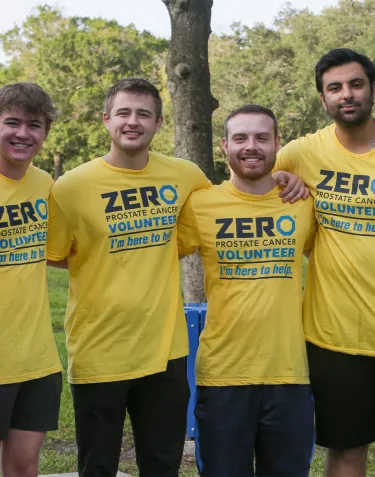 A group of four young men wearing yellow ZERO Volunteers t-shirts at the Tampa Run/Walk event in 2023
