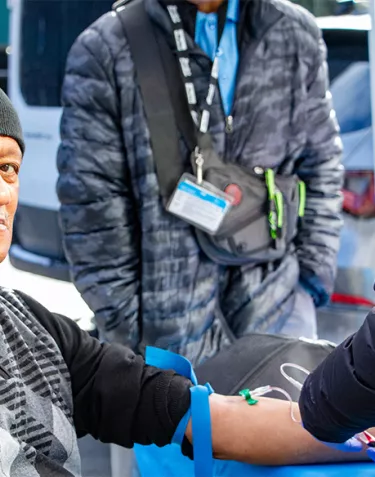 A man getting a PSA blood test, with his sleeve is rolled up and a needle in his arm