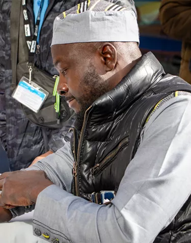 A black man holding a cotton ball on his arm