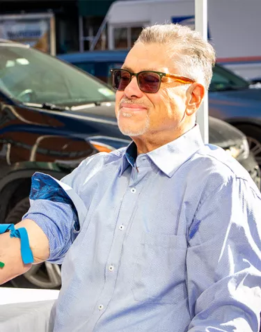 A man having his blood drawn at a mobile test site