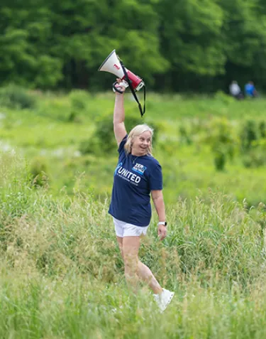 Tracy Cameron holding bullhorn in field