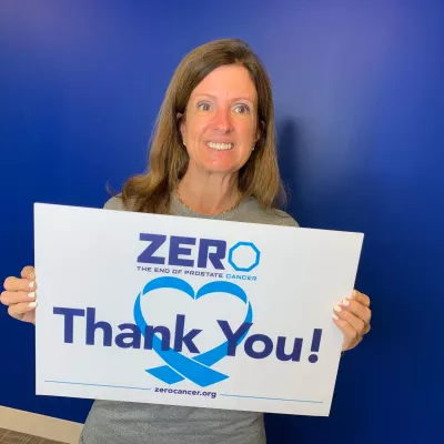 Sandy Maxey holding up a thank you ZERO sign