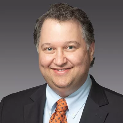 Middle-aged man in a suit smiling at the camera