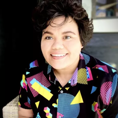 Woman in a colorful patterned shirt, Sarrah Bates