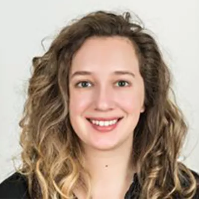 Headshot of a young woman with curly hair—Brianna Abbott, health reporter at the Wall Street Journal