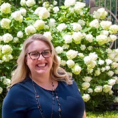 Headshot of Amanda Hasse in front of white flowers