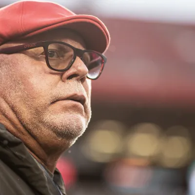 Man in a red had wearing eye glasses