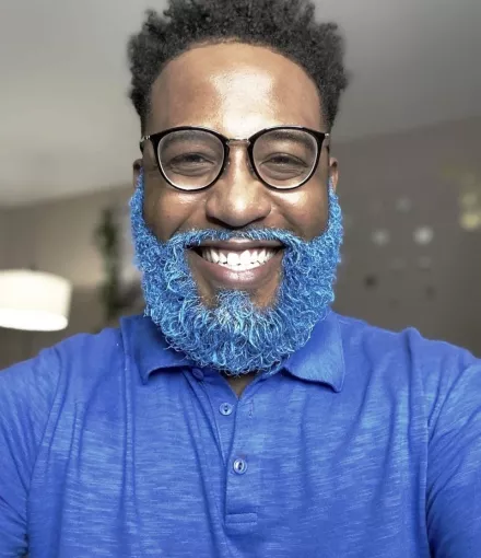 African American man in a blue t-shirth with blue beard