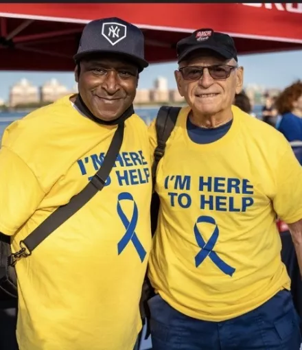 African American and white man in yellow t-shirts volunteering at a ZERO Prostate Cancer event