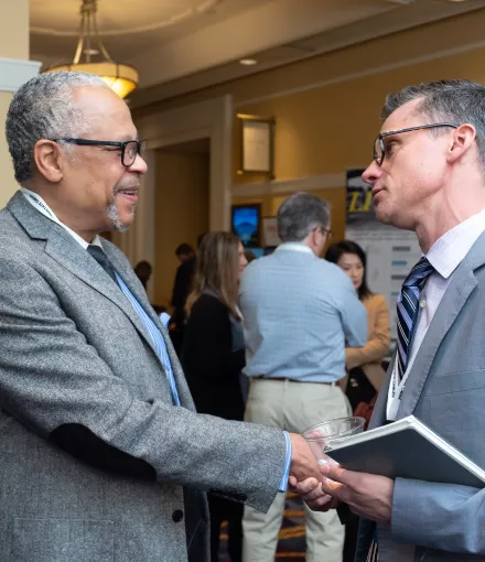 Two men in grey suits shaking hands