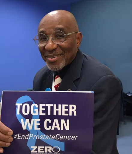 Black man holding a sign that says "Together We Can"