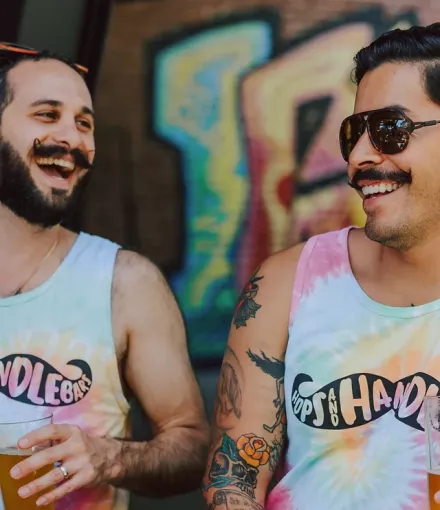 Two men laughing during the Hops and Handlebars fundraiser